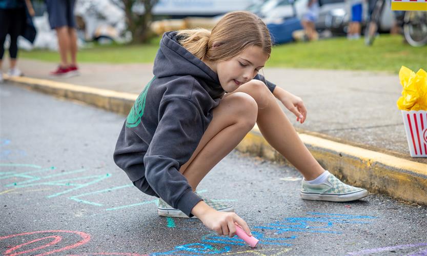A girl colors with chalk